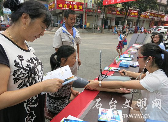图为大药房工作人员正在免费给群众测量血压