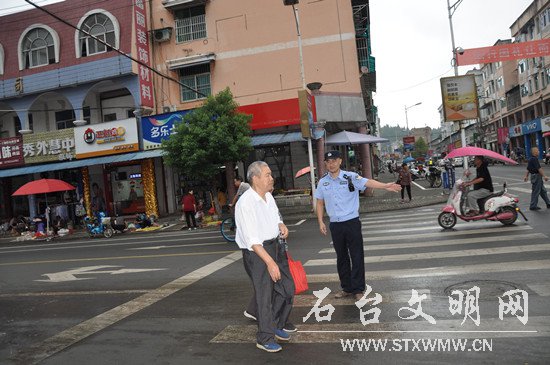 9月7日上午,石台县公安局一参加文明交通劝导活动的机关民警在引导一对老夫妻安全通过路口