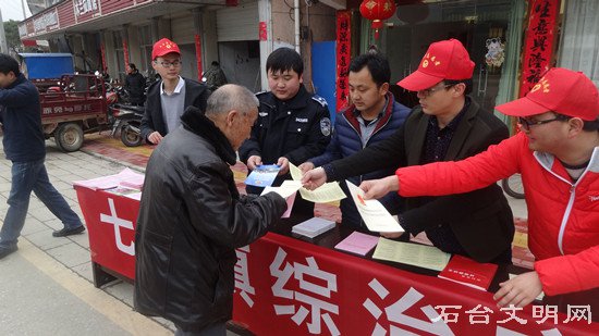 图为志愿者为群众发宣传单