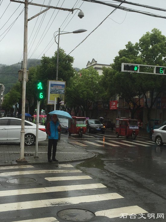 图为志愿冒雨参加文明交通劝导活动