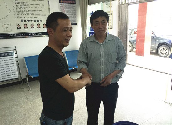 失主与捡拾钱包的好人握手